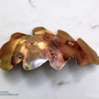 Brass Barrette Oak Leaf Hair Clip, Mixed metal look rustic barrette. Handcrafted from pure brass, torch fired, metal balls soldered on the brass with copper tones coming through the metal. Nice one of a kind torched rustic metal hair clip, no other one quite like this one is going to walk by! This leaf barrette was handcut from brass sheet, shaped and formed and then torch fired. The top side is sealed with jewelry clear coat. Glued with a high grade glue that stays a bit flexible to take the repeated use. Pure brass, one of a kind handmade creations for your special hair accessory collection! About 5 x 2 inches. Standard 3 inch barrette spring clasp. The barrette clip is a  3 inch size clip (medium). It will generally accommodate all of thinner or fine hair and with thicker hair you can wear it office chic with part of the hair pulled back with it or over a ponytail holder where you attach it to just part of the hair.  Please email me with any questions. Handmade in the USA.